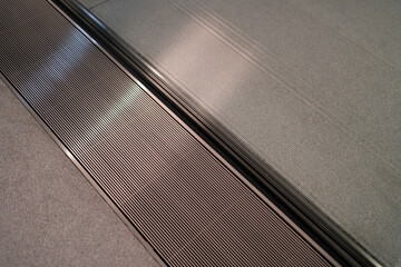 Close-up of a textured floor surface with parallel lines, showing an air conditioning vent embedded in the floor design.