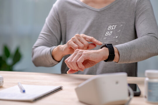 Senior Asian Woman taking blood pressure test on smartwatches, in concept of Augmented reality, Application Interface design, UX UI design, and Health care - Powered by Adobe