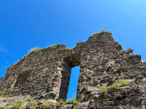 Ruin of a wall and passageway of Useldange castle under blue skies. Luxembourg.