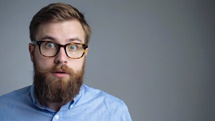 A man with a beard and glasses, wearing casual clothing, expressing surprise or shock.
