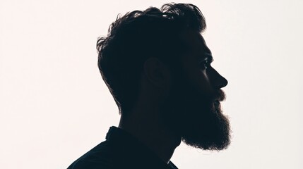 Silhouette of a bearded man with fade effect against a clean white background at an indoor setting
