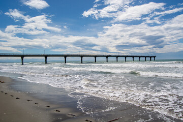 Coastal Pier with Waves and Clouds