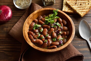 Baked red beans in bowl on wooden table