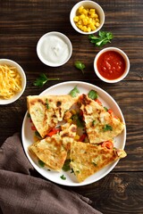 Chicken quesadilla with fresh vegetables served with sauce, top view