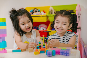 Fototapeta premium Girls happily play with developmental toys.
