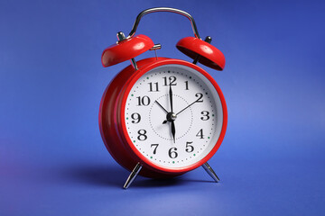 One red alarm clock on color background