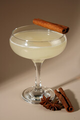 Cinnamon cocktail on beige background. Alcoholic cocktail