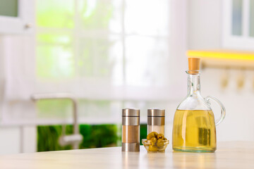 Salad dressings, spices and olives on table in kitchen. Space for text