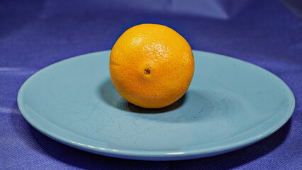 Fresh, juicy orange, a healthy citrus fruit, are isolated on a blue plate