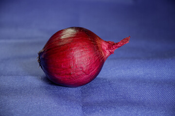Fresh red onion, a healthy organic vegetable ingredient, isolated on a natural wooden background