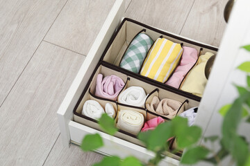Organizers with folded clothes in drawer indoors, above view