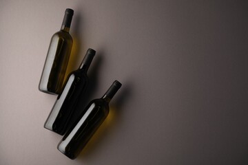 Bottles of wine on grey background, flat lay. Space for text