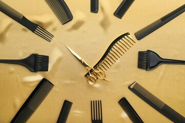 Fototapeta premium Clock made with hairdresser's tools on golden fabric, flat lay