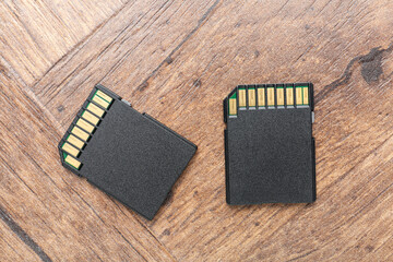 Two SD memory cards on wooden table, top view
