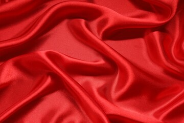 Red crumpled silk fabric as background, top view