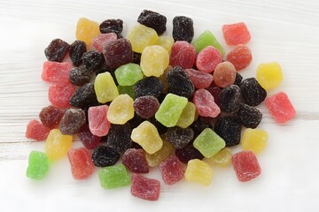 Colorful Assorted Fruit Jellies Candy Pile on White Wooden Background
