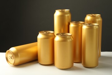 Many tin cans on white table against grey background