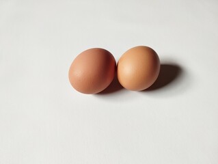 Two brown chicken eggs on a white background 