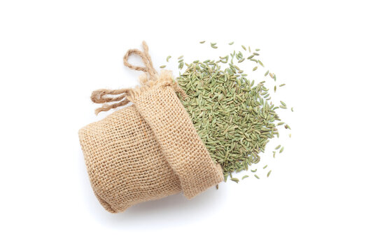 Close-up of Dry Organic Fennel Seeds (Foeniculum vulgare), spilled out from a laying jute bag. Isolated on a white background.