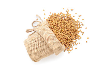 Close-up of Dry Organic Fenugreek seeds (Trigonella foenum-graecum), spilled out from a laying jute bag. Isolated on a white background.