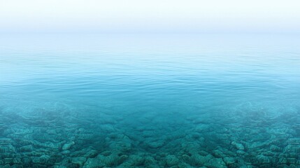 Fototapeta premium A serene body of water with a rocky bottom and a light blue sky above.