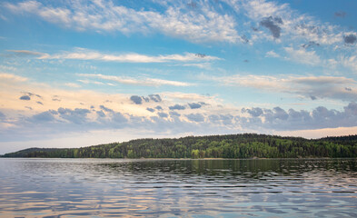 A calm lake with a cloudy sky in the background
