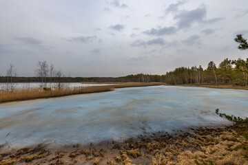 A lake with a cloudy sky in the background