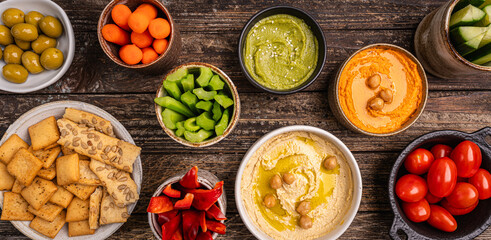 Various hummus dips. Hummus plate with vegetable snacks. Carrot, cucumber, tomato, celery sticks,...