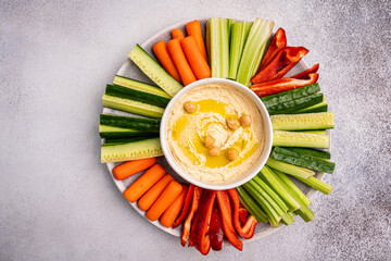 Various hummus dips. Hummus plate with vegetable snacks. Carrot, cucumber, tomato, celery sticks,...