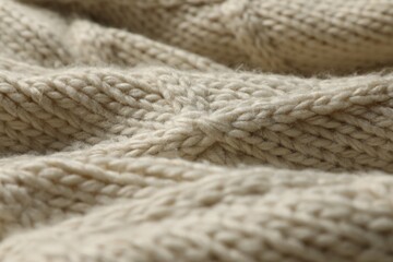 Beige knitted wool texture as background, closeup