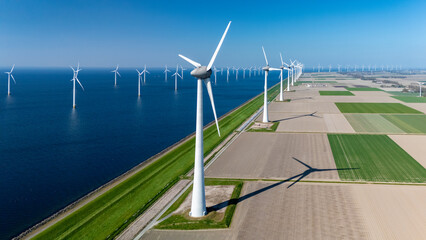 Vast fields meet the North Sea as a modern offshore wind farm operates near the Netherlands. Wind...