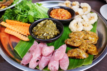 Fototapeta premium Northern Thai spicy green chilli dip with sausage and crackling with vegetable set on banana leaf is traditional Thai food