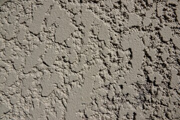 Vue de près sur un mur en crépi gris