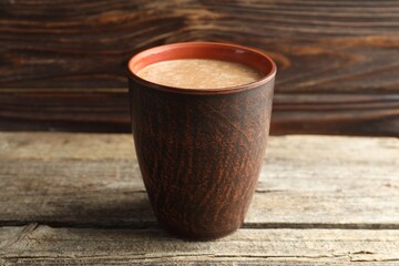 Aromatic Masala tea in cup on wooden table, closeup