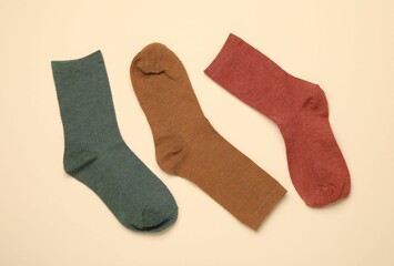 Many different socks on beige background, flat lay