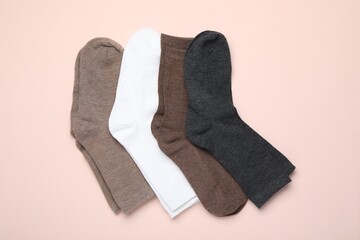Many different pairs of socks on beige background, flat lay