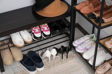 Many different shoes on racks in entryway, closeup