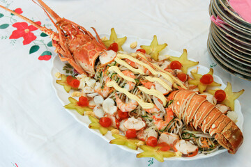 Lobster salad on a white platter with starfruit and tomato garnish