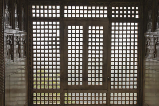 Traditional wooden window with a grid or lattice design, made of wood. Photo from Agra's Red Fort in India. UNESCO World Heritage Site.