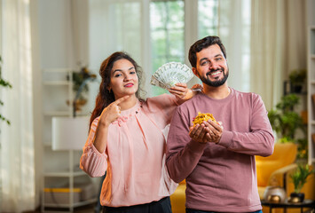 Confused man with jewelry, wife surprises with money fan — celebrating gold loan approval