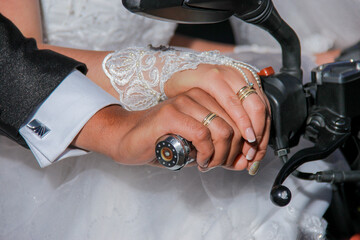 07 September 2019, Bogotá, Colombia – Bride and groom hold hands on a motorcycle handlebar after...