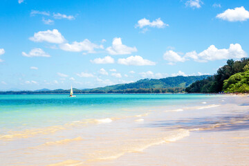 Sea coast with white clean sand and azure water with a sailboat. Travel and tourism. Seascape