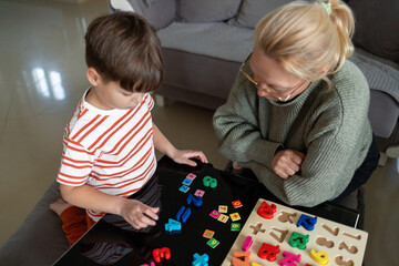 Child learning to count with wooden numbers and adult guidance at home