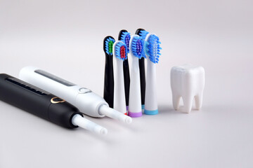 Modern electric ultrasonic toothbrush with rechargeable battery on a gray surface.