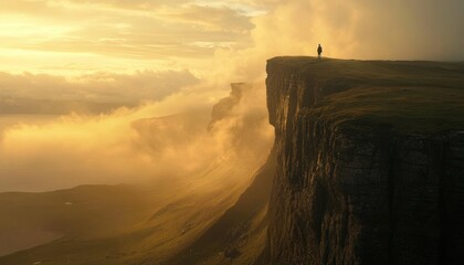 Golden hour silhouette on a dramatic mountain precipice.