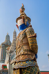 Close up the back colorful Yaksha guardian statue in ornate armor under blue sky at the entrance of...
