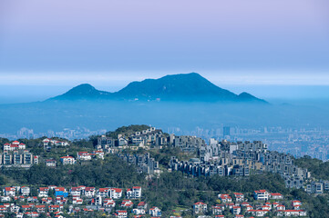 A tranquil spring morning at Lion's Head Mountain in Xindian, Taiwan, with white clouds rolling gently over the mountain peaks, creating a serene and picturesque view.
