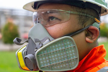 Close-up of South east asia man as  construction worker wearing a respirator mask and safety...