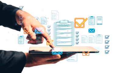 Hands of a businessperson using a tablet, with floating checklist and email icons in a modern graphic style on a white background, digital task concept