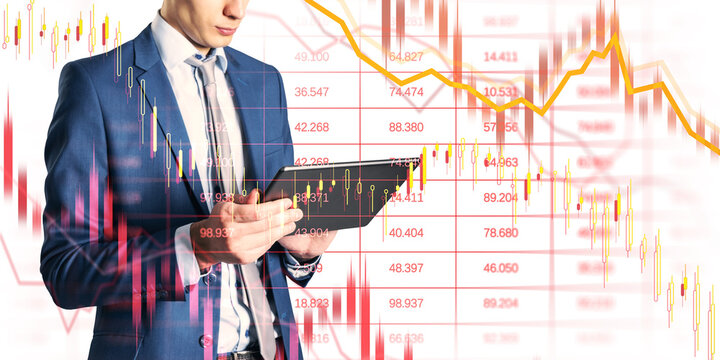 Man in suit using tablet, candlestick and line charts superimposed, light background, concept of financial crisis and market collapse - Powered by Adobe